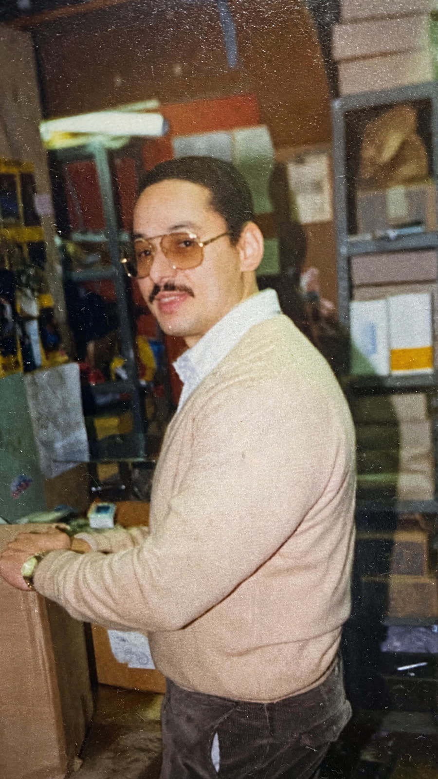 Randolph Nicholas at the store in the 1980s, wearing tinted glasses